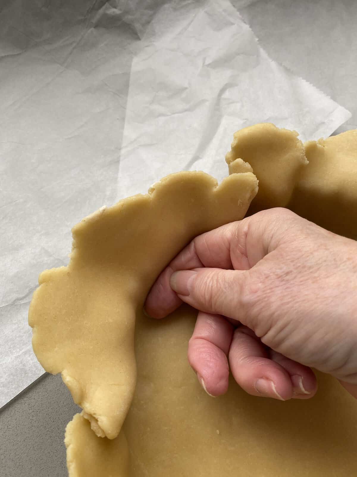 Fitting the pastry dough in the tart tin.