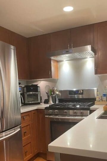 Kitchen with large fridge to the left and countertop to the right.