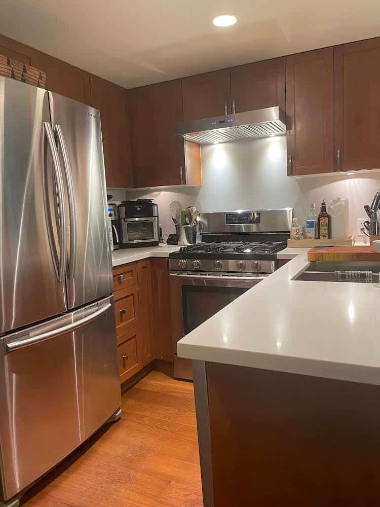 Kitchen with large fridge to one side.
