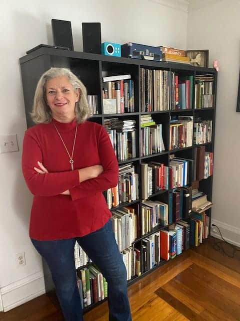 Julie McCoy in front of her bookshelves.