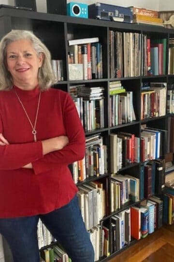 Julie McCoy in front of her bookshelves.