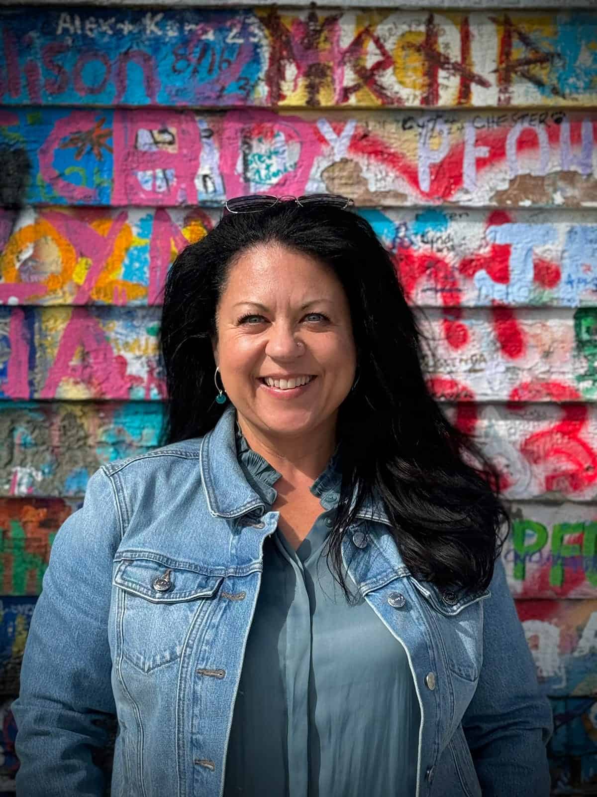 Rebecca Blackwell in front of a colourful wall.