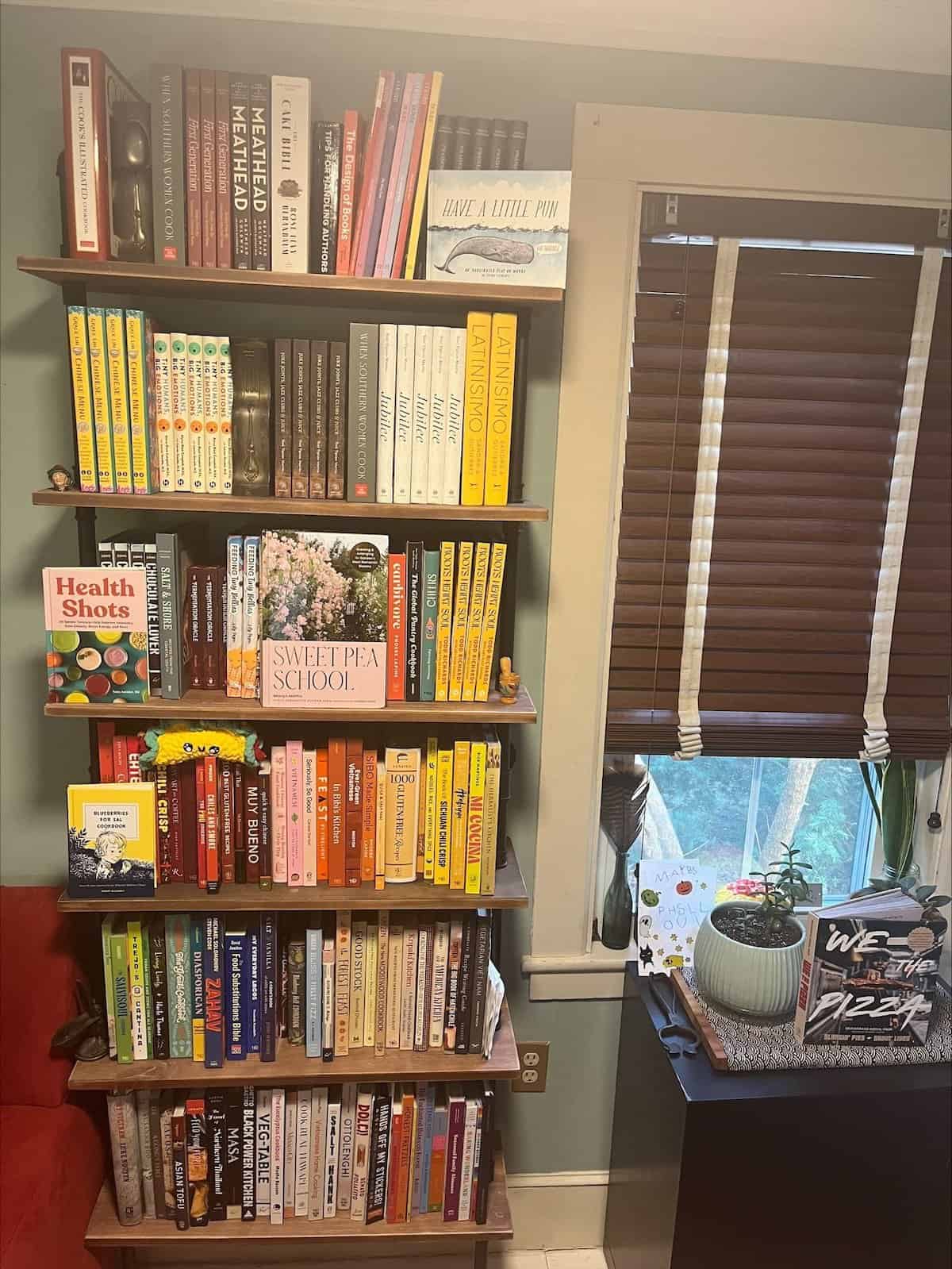 Sally Ekus's tall bookshelves, with a window and desk to the side. 