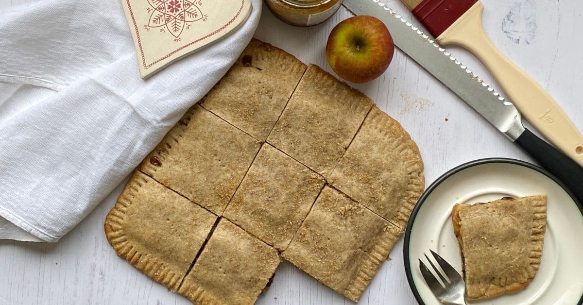 Mincemeat squares on a counter top with a slice cut out.  Mincemeat and apple squares cut into portions.